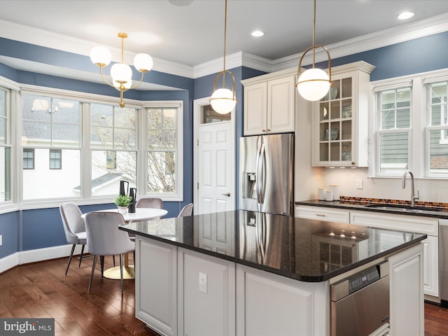 kitchen featuring dark wood finished floors, a sink, a kitchen island, glass insert cabinets, and stainless steel refrigerator with ice dispenser