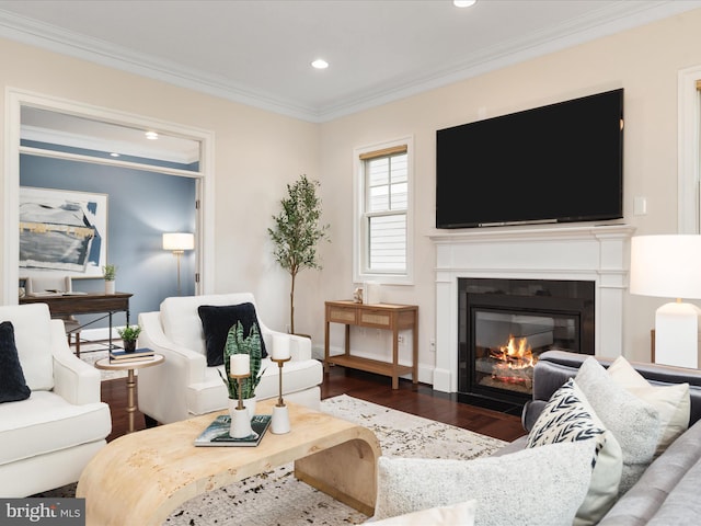 living area featuring a glass covered fireplace, wood finished floors, recessed lighting, and crown molding