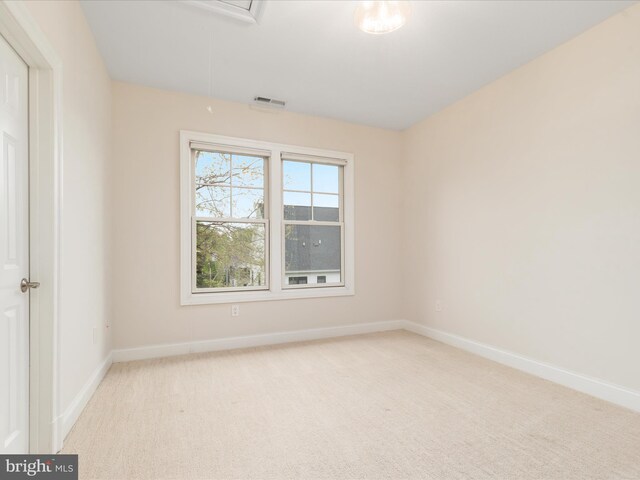 unfurnished room featuring light colored carpet, baseboards, and attic access