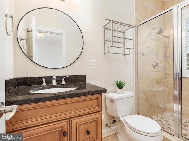 bathroom with vanity, a shower stall, and toilet