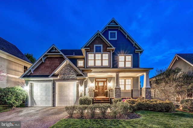 craftsman house featuring a porch, driveway, stone siding, and a garage