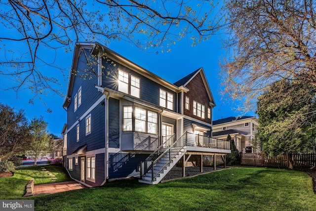 rear view of house with a yard, stairway, fence, and a deck