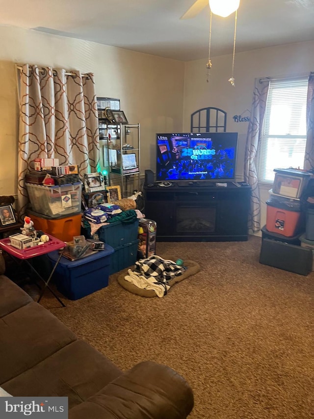 living area featuring ceiling fan and carpet flooring