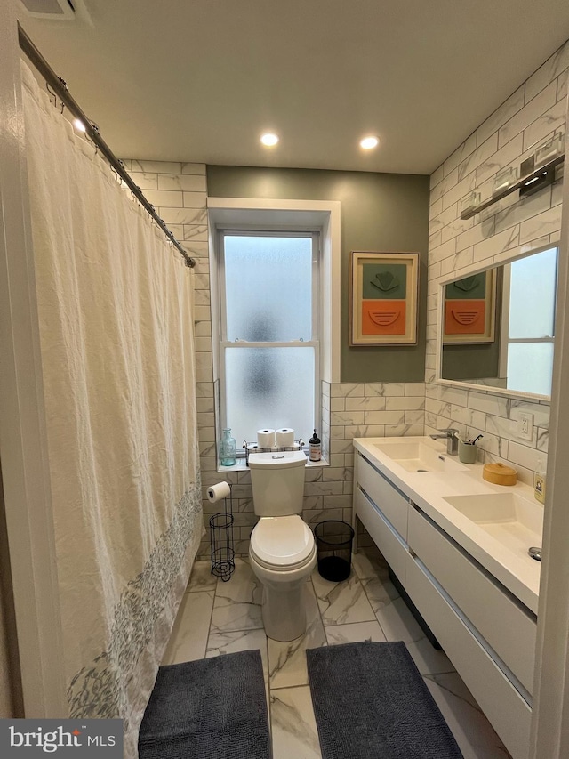 full bathroom with toilet, recessed lighting, a sink, tile walls, and marble finish floor