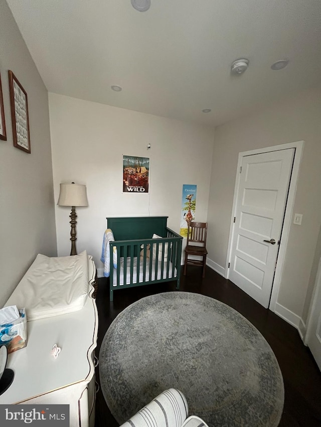 bedroom with dark wood-style flooring and baseboards