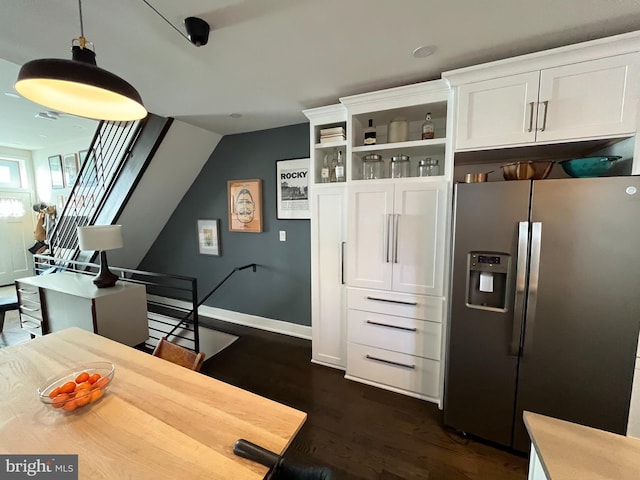 interior space featuring dark wood-type flooring, white cabinets, light countertops, stainless steel refrigerator with ice dispenser, and open shelves