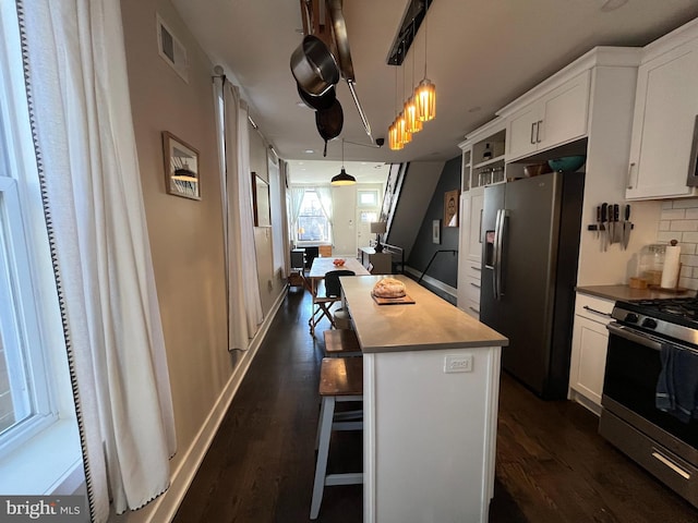 kitchen featuring white cabinetry, visible vents, appliances with stainless steel finishes, and tasteful backsplash