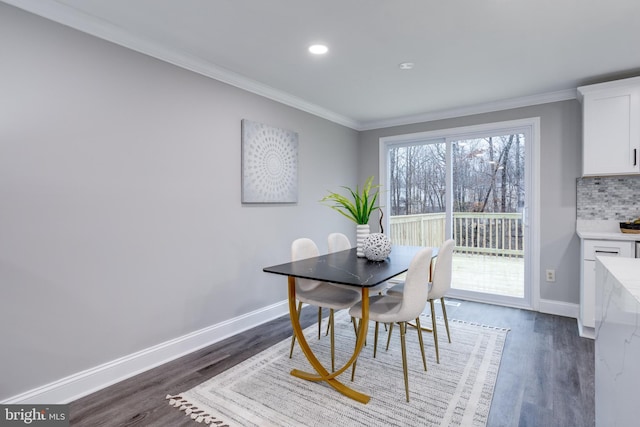 dining room with baseboards, ornamental molding, and dark wood-type flooring