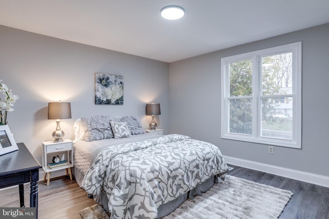 bedroom featuring baseboards and wood finished floors