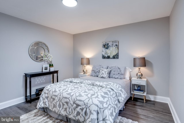 bedroom featuring baseboards and dark wood finished floors