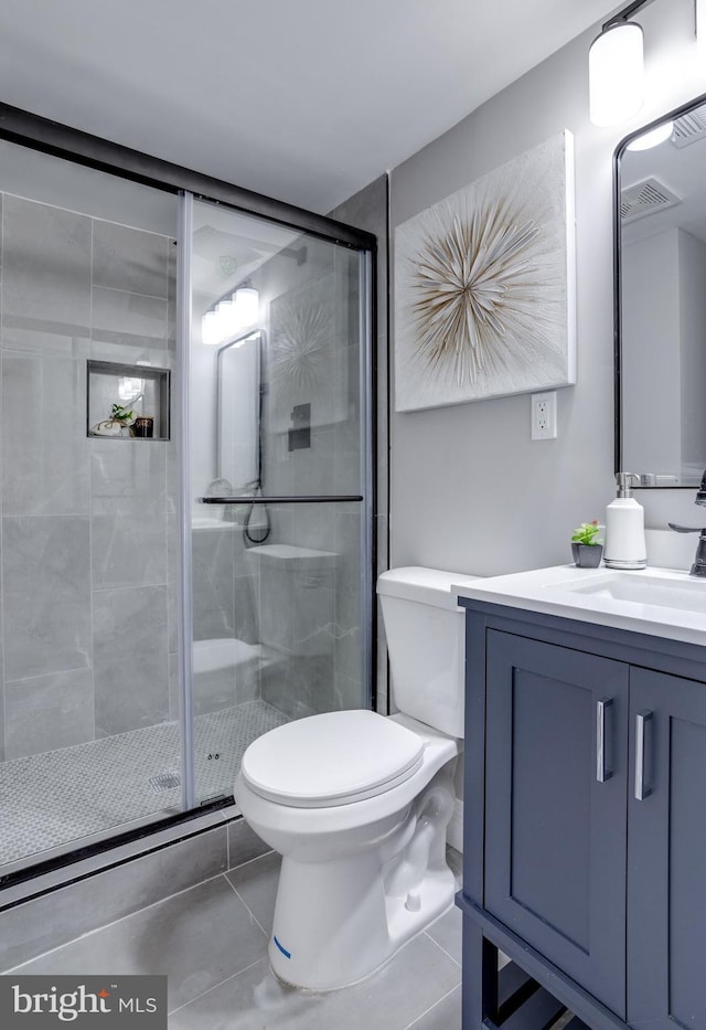 full bath featuring toilet, a shower stall, vanity, and tile patterned floors