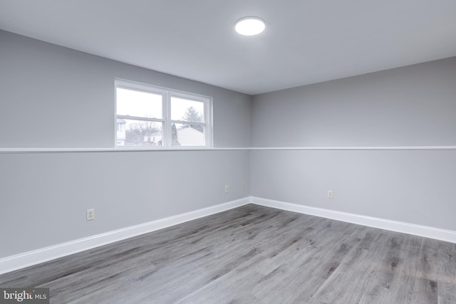 empty room featuring wood finished floors and baseboards