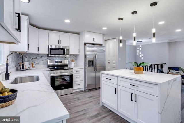 kitchen featuring decorative backsplash, light wood-style flooring, appliances with stainless steel finishes, white cabinetry, and a sink