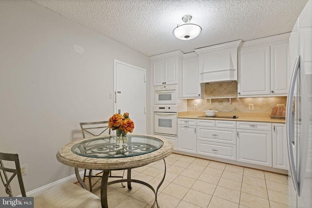 kitchen with light countertops, backsplash, and white cabinetry