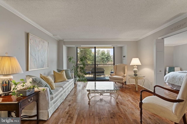 living area featuring a textured ceiling, ornamental molding, and wood finished floors