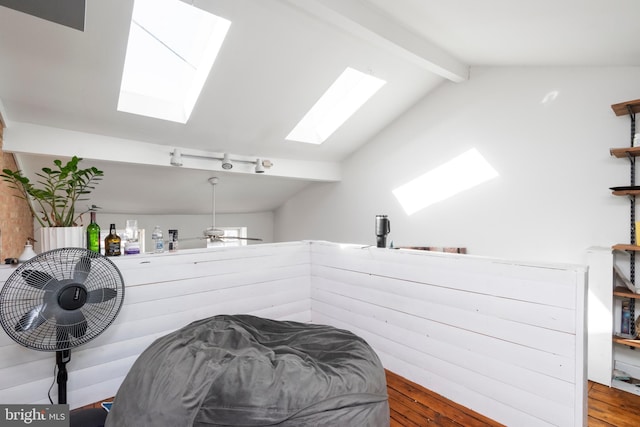 interior space featuring vaulted ceiling with skylight, ceiling fan, and wood finished floors