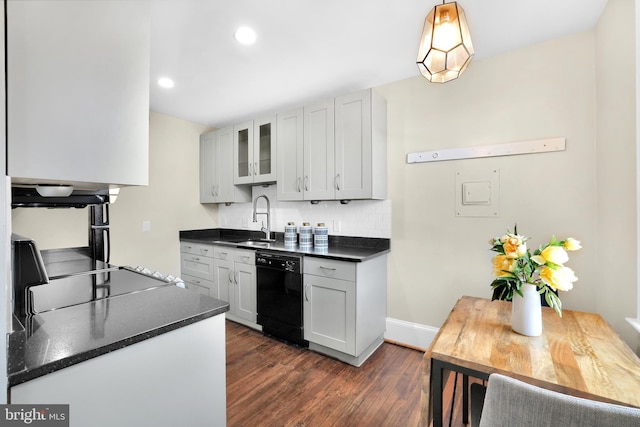 kitchen with dishwasher, dark countertops, a sink, and glass insert cabinets