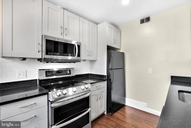 kitchen featuring appliances with stainless steel finishes, white cabinets, and decorative backsplash