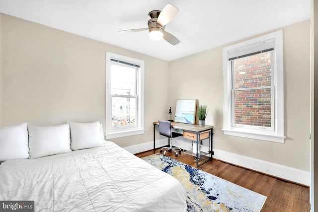 bedroom with wood finished floors, a ceiling fan, and baseboards