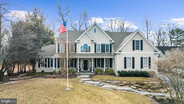 view of front of house featuring a shingled roof, covered porch, board and batten siding, and a front lawn