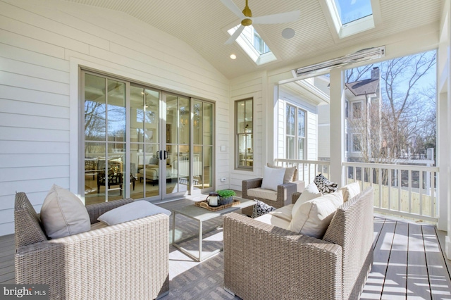 sunroom / solarium with vaulted ceiling with skylight and a ceiling fan