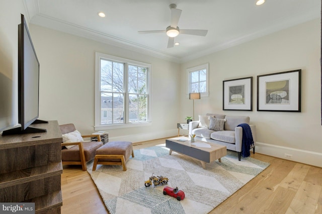 living area featuring crown molding, recessed lighting, a ceiling fan, light wood-type flooring, and baseboards