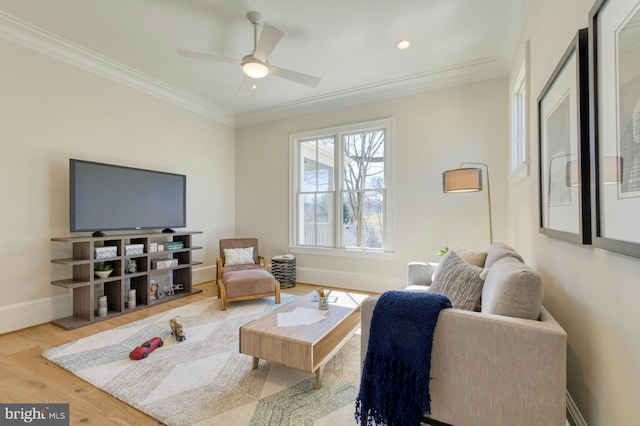 living room featuring baseboards, ornamental molding, ceiling fan, and wood finished floors