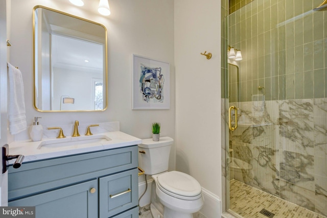 bathroom with toilet, a stall shower, baseboards, and vanity