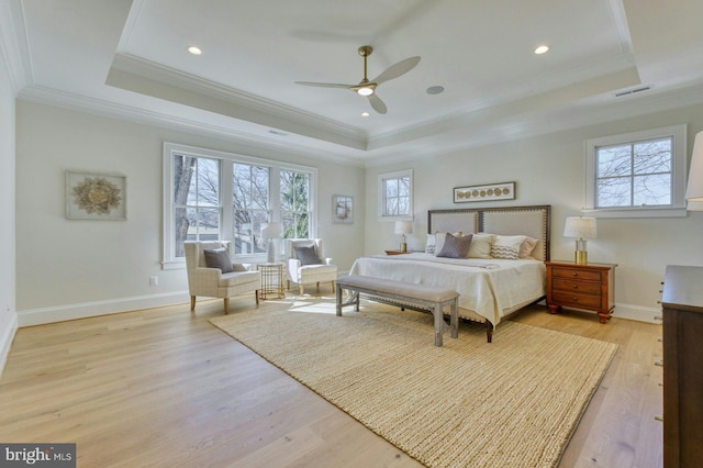 bedroom featuring a tray ceiling, multiple windows, and visible vents