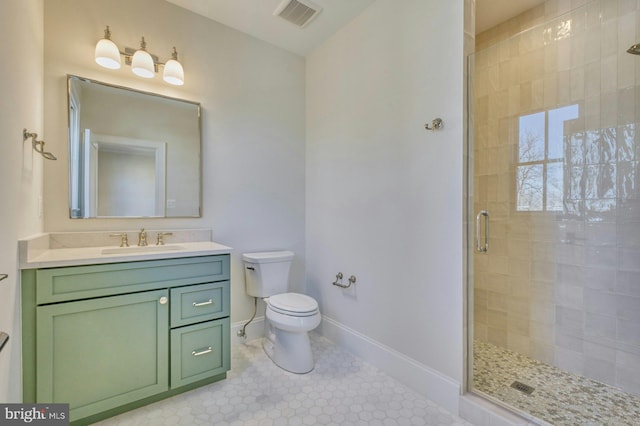 bathroom featuring toilet, vanity, visible vents, baseboards, and a stall shower