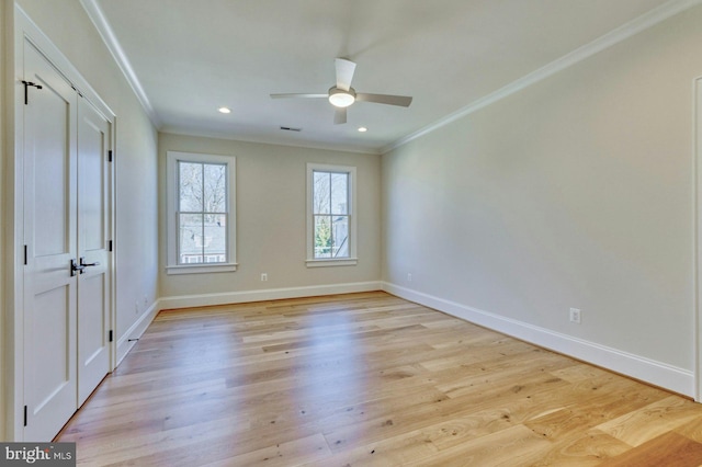 unfurnished room with crown molding, light wood finished floors, and baseboards