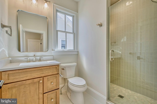 bathroom with toilet, a shower stall, vanity, baseboards, and tile patterned floors