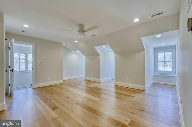 bonus room featuring a healthy amount of sunlight, light wood-style flooring, visible vents, and ceiling fan