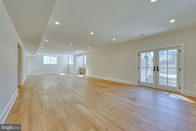 unfurnished living room featuring light wood finished floors, french doors, and recessed lighting