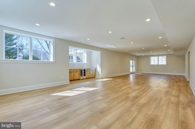 unfurnished living room featuring wine cooler, light wood-style flooring, and recessed lighting