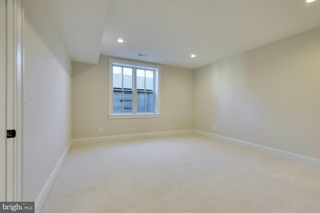 spare room featuring light carpet, recessed lighting, visible vents, and baseboards