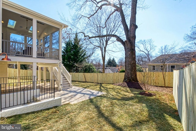 view of yard with a patio, stairway, a fenced backyard, and a sunroom