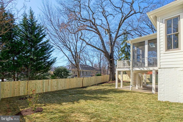 view of yard featuring a sunroom and a fenced backyard