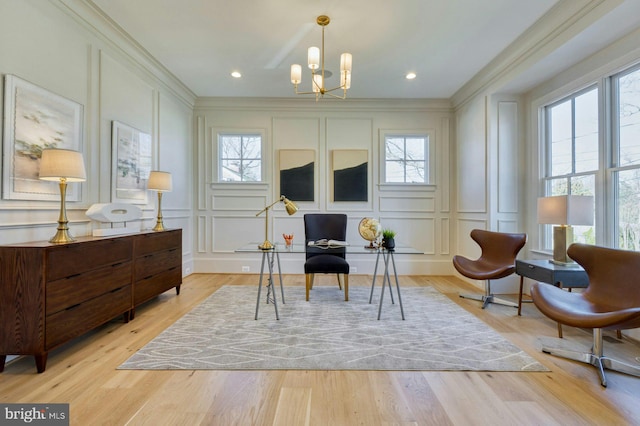 living area featuring ornamental molding, a decorative wall, and light wood finished floors