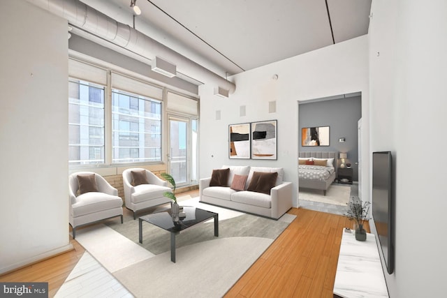 interior space with baseboards, a high ceiling, and light wood-style floors