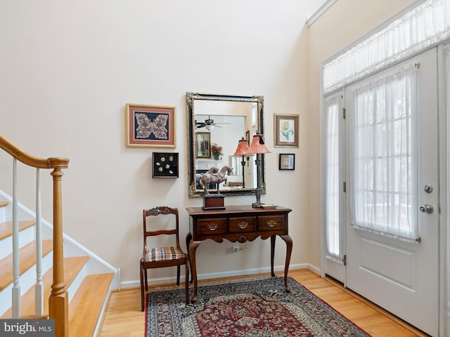 entryway featuring a healthy amount of sunlight, light wood finished floors, and stairs