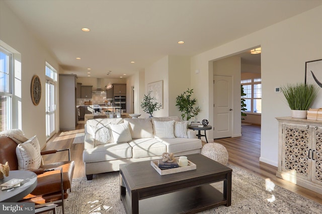 living area with light wood-style flooring and recessed lighting