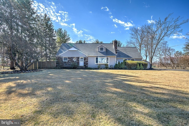 view of front of property featuring fence, a chimney, and a front lawn