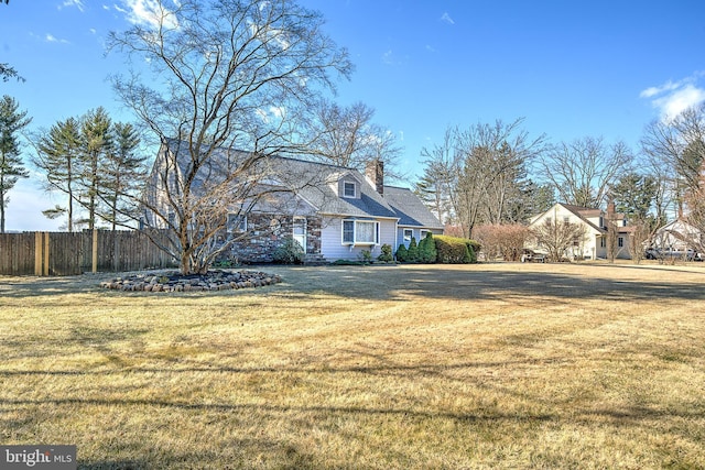 view of property exterior featuring a yard, fence, and a chimney