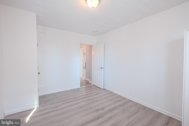 spare room with light wood-style flooring and baseboards