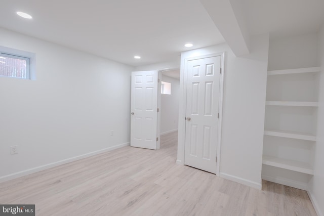 basement with baseboards, light wood finished floors, and recessed lighting