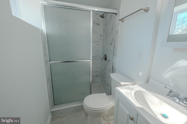 bathroom featuring a stall shower, marble finish floor, vanity, and toilet