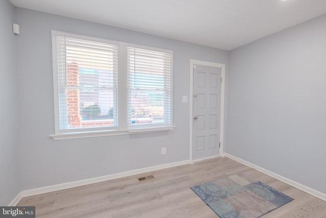 foyer entrance featuring light wood-type flooring, visible vents, and baseboards