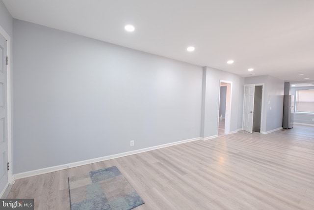 spare room featuring baseboards, recessed lighting, and light wood-style floors