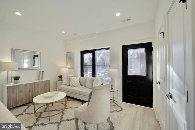 living room featuring recessed lighting, visible vents, and light wood finished floors